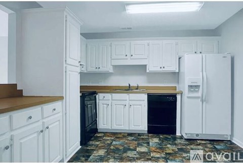 A kitchen with white cabinets and a black dishwasher.