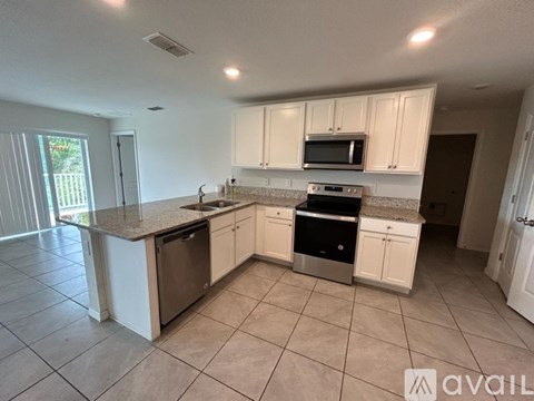 A kitchen with white cabinets and appliances is available for rent.