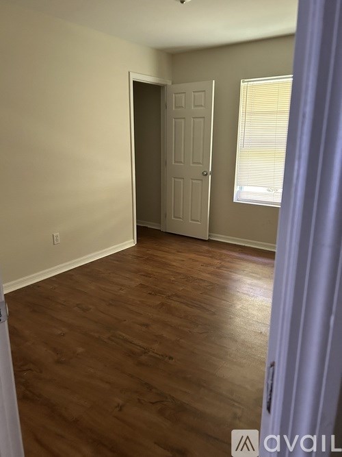 A room with a wooden floor and a white door.