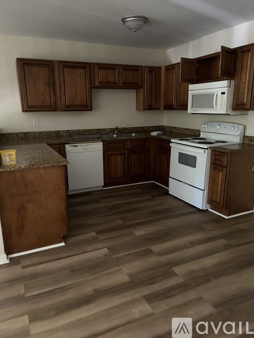 A kitchen with wooden cabinets and white appliances.