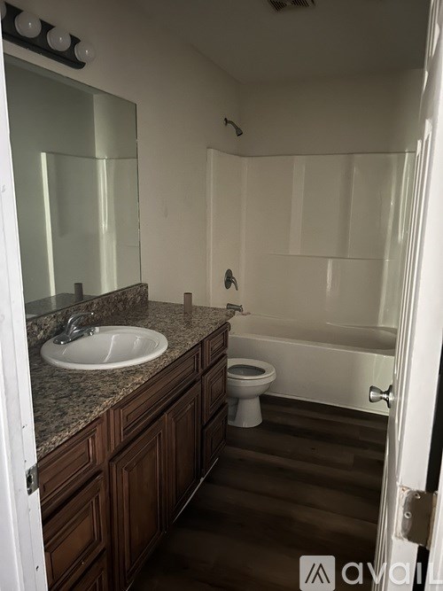 A bathroom with a sink, toilet, and bathtub.