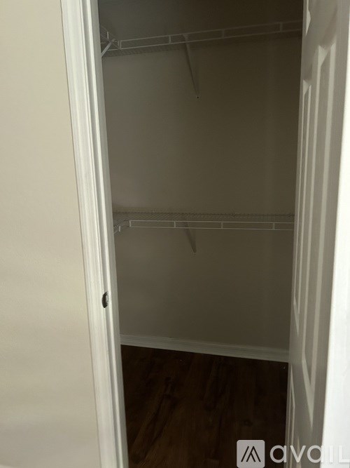 A white closet with a door slightly ajar.