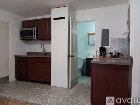 A kitchen with brown cabinets and a white door.