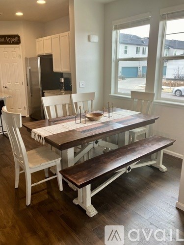 A dining room with a wooden table and bench seating.