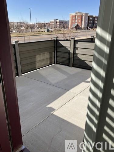 A view from a doorway looking out to a parking lot and buildings.
