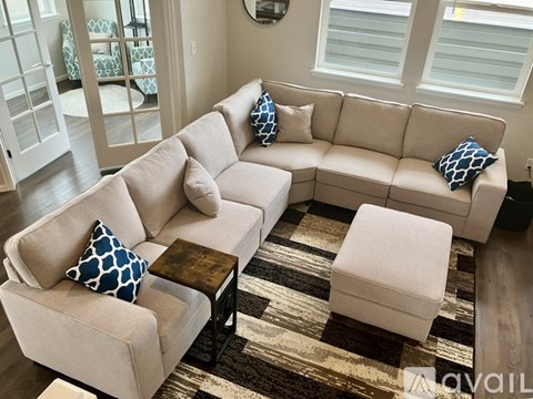 A beige couch with blue and white pillows sits in a living room.