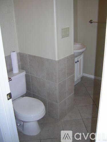 A white toilet in a bathroom with tiled walls.