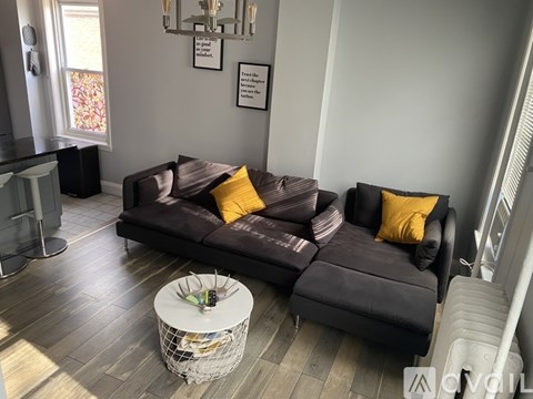 A living room with a brown couch and a white coffee table.