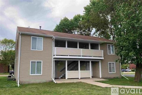 A two-story house with a balcony on the second floor.