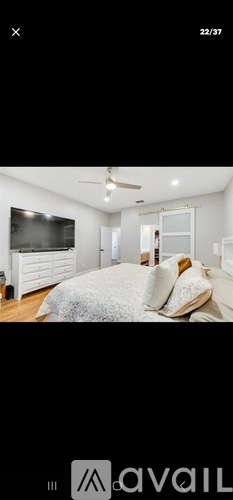 A bedroom with a large bed and a ceiling fan.