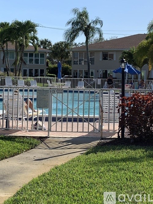 A pool surrounded by a metal fence and a walkway.