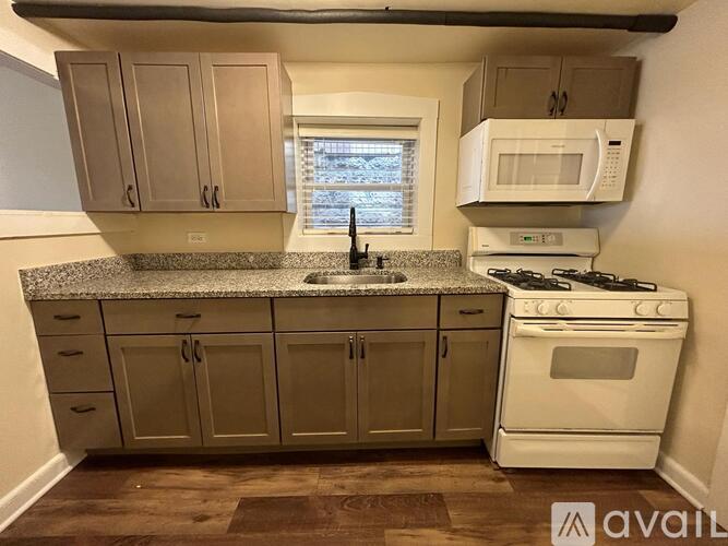 A kitchen with a white stove top oven and a microwave above it.