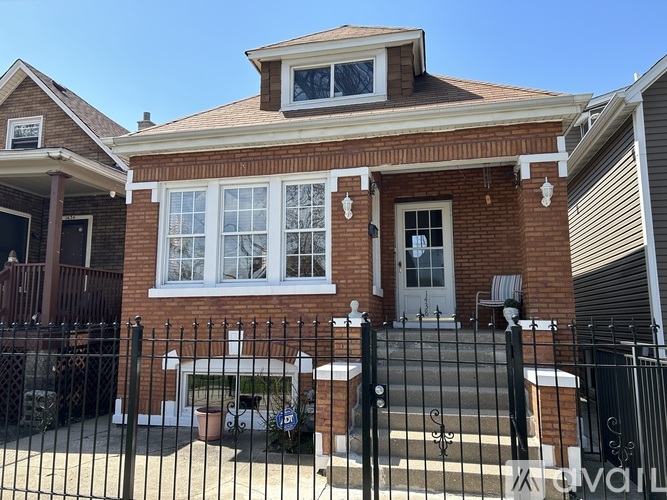 A red brick house with a white door and windows.