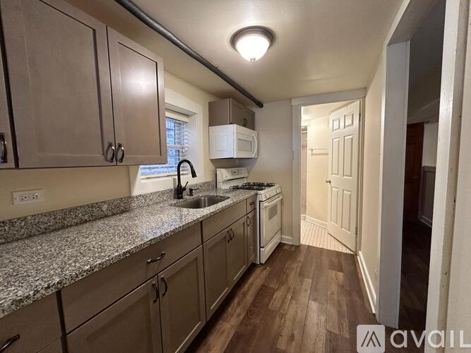 A kitchen with granite countertops and wooden floors.