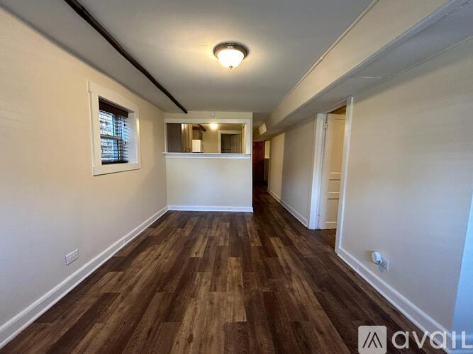 A room with wooden flooring and white walls is available for rent.