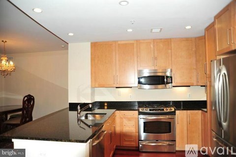 A kitchen with wooden cabinets and a black countertop.