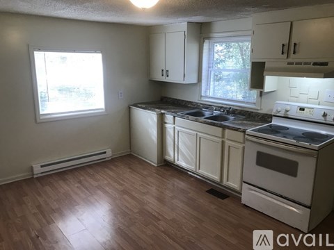 A kitchen with white cabinets and a stove top oven.