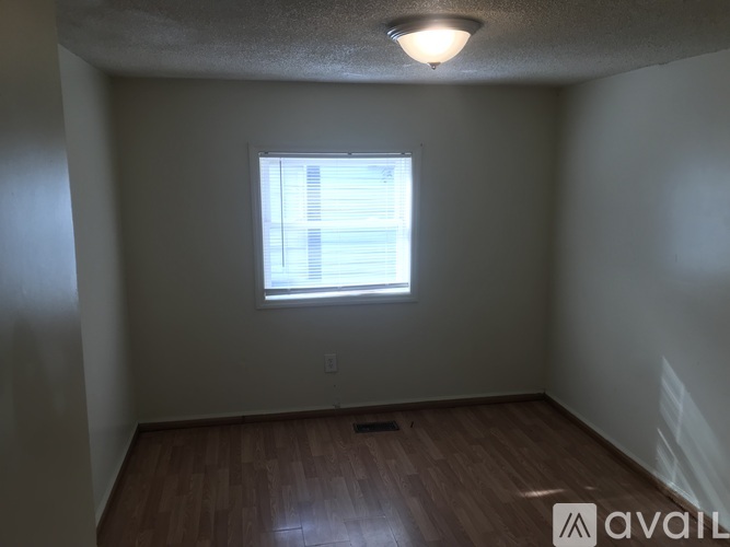 A room with a window and wooden flooring.