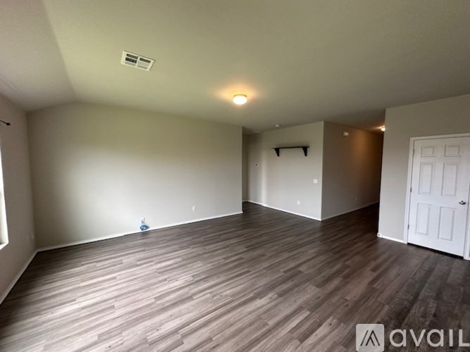 A room with wooden flooring and a white door.