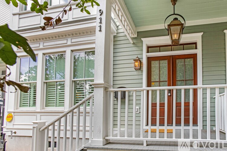 A house numbered 911 has a white porch and a brown door.