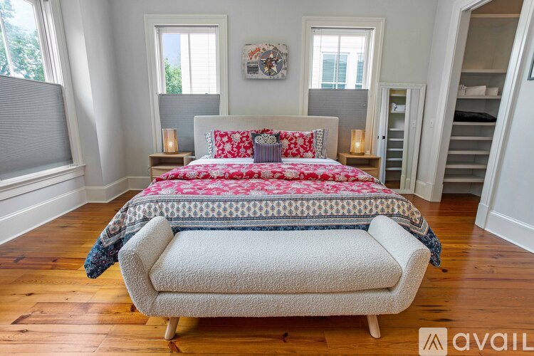 A bedroom with a large bed and a chair in front of it.