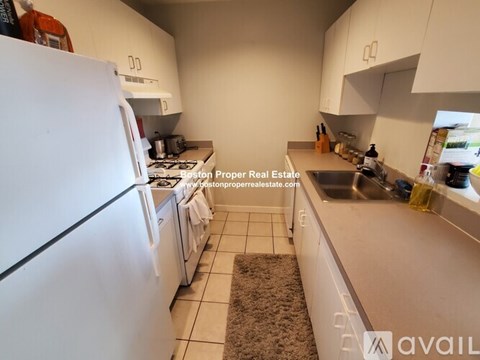A kitchen with white appliances and cabinets.
