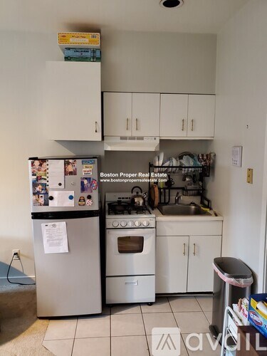 A kitchen with a refrigerator, oven, and cabinets.