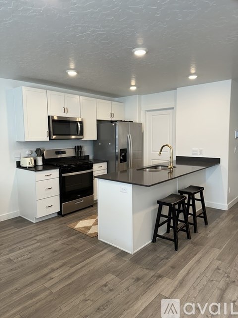 A kitchen with white cabinets and a black countertop.