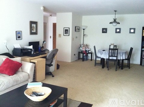 A living room with a couch, a dining table, and a television.