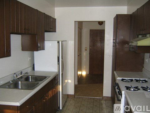 A kitchen with brown cabinets and a white refrigerator.