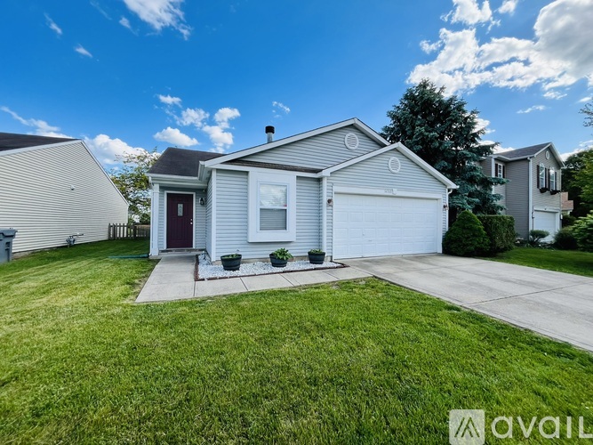 A house with a red door and a garage is for sale.