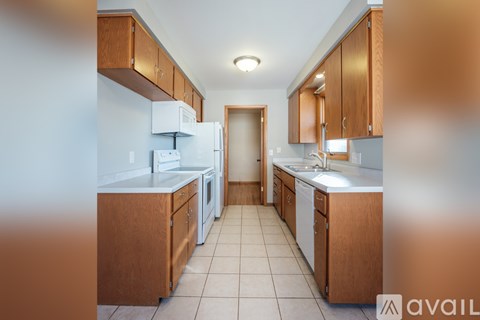 A kitchen with wooden cabinets and white appliances.