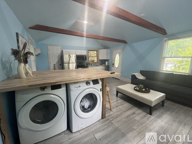A laundry room with two washing machines and a bench.
