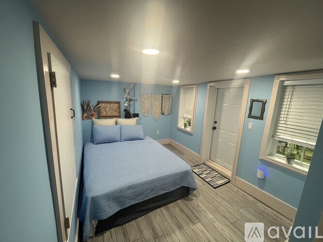A bedroom with a bed, pillows, and a window with blinds.