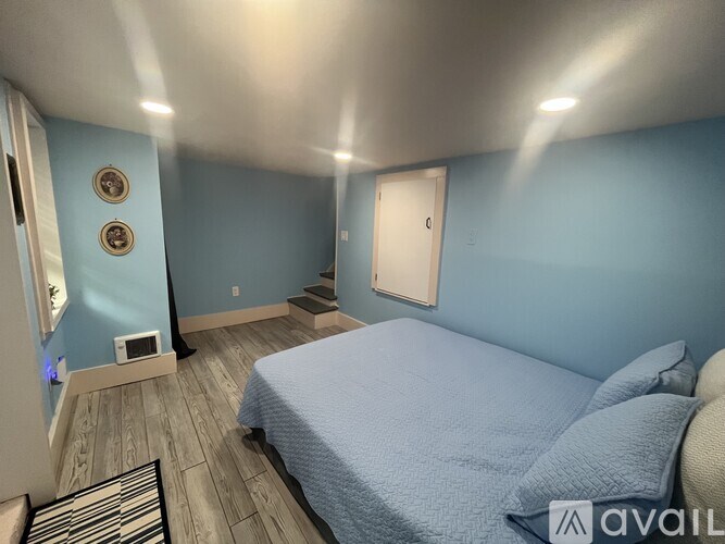 A bedroom with a bed, a mirror, and a door.