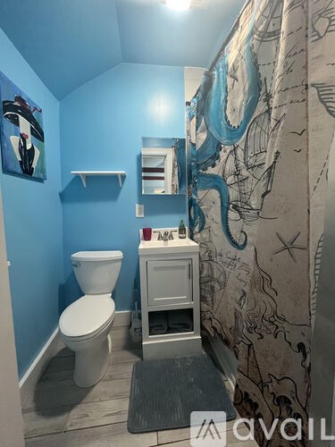 A bathroom with a toilet, sink, and a blue wall.