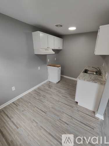 A kitchen area with white cabinets and a countertop.