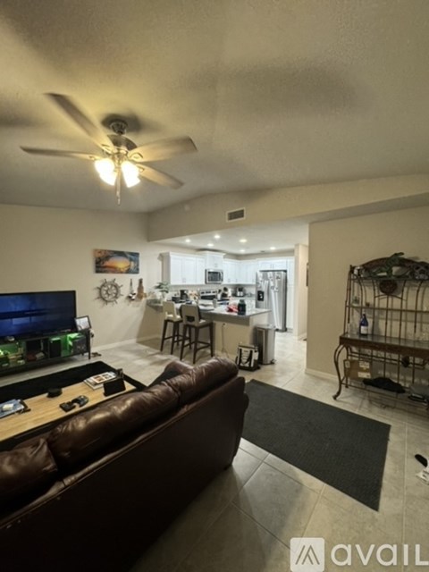 A living room with a brown leather couch and a television.