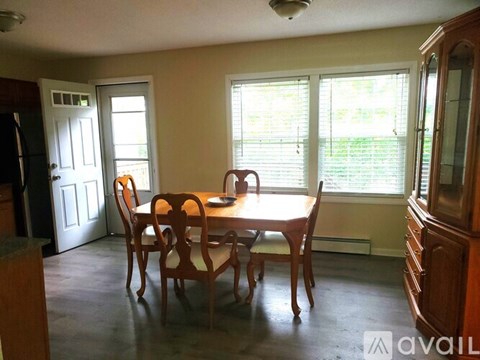 A dining room with a wooden table and chairs.