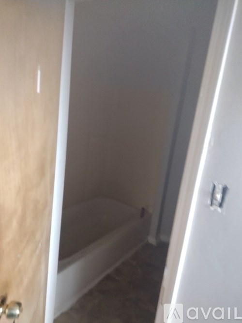A bathroom with a tub and a toilet.