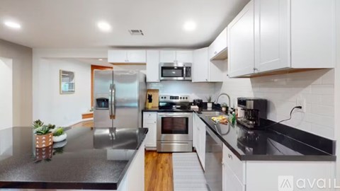 A modern kitchen with stainless steel appliances and white cabinets.