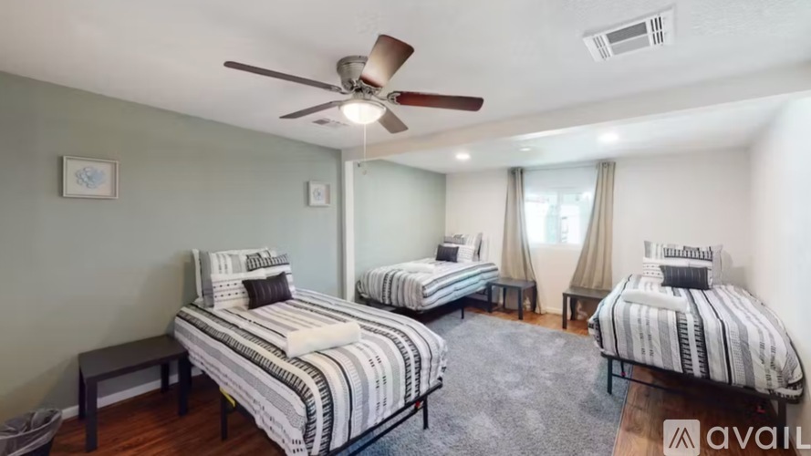 A bedroom with two beds and a ceiling fan.