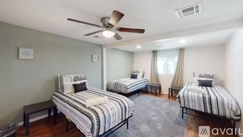 A bedroom with two beds and a ceiling fan.