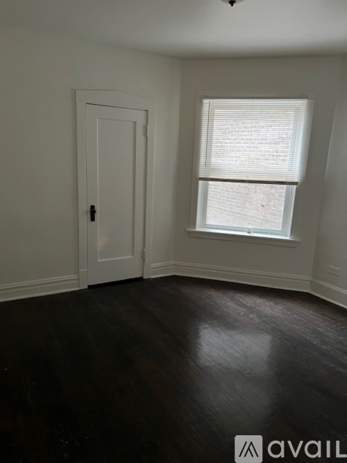 A room with a door and a window with blinds.