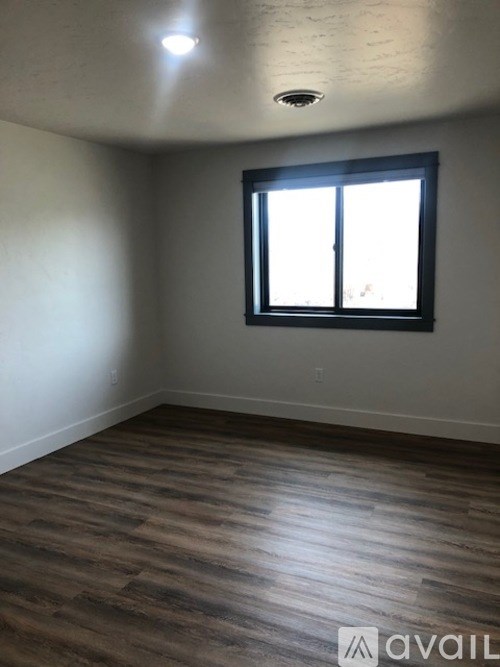 A room with a window and wooden flooring.