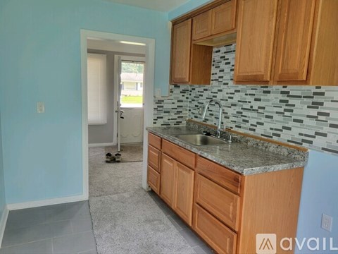 A kitchen with wooden cabinets and a granite countertop.