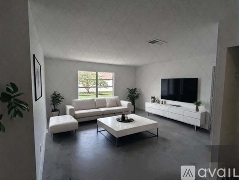 A modern living room with a white sofa set and a television.