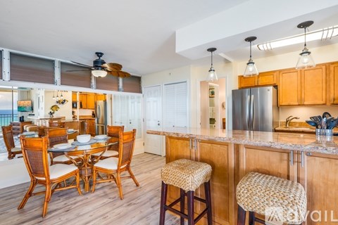 A kitchen with wooden chairs and a bar stool.