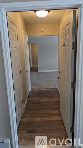 A room with a striped carpet and a door on the right side.