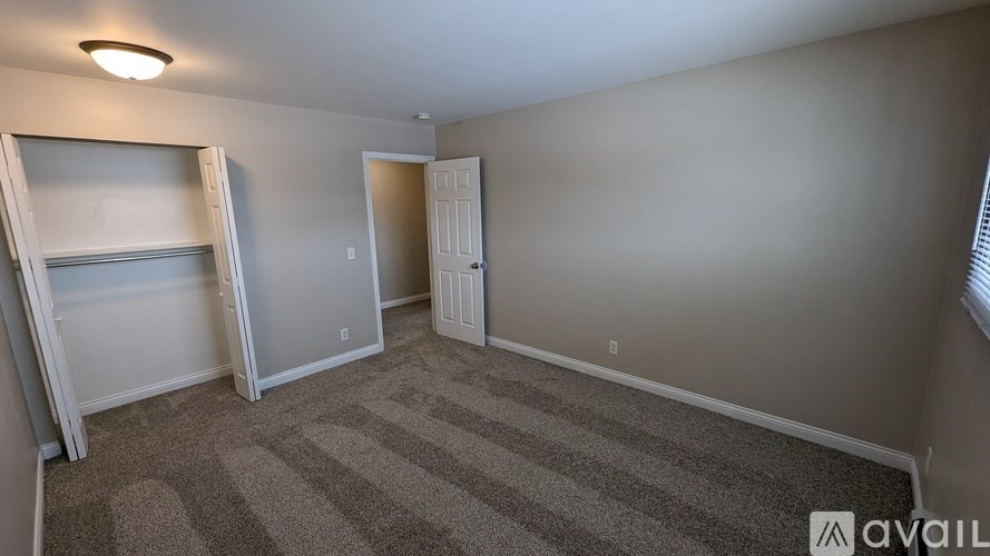 A room with a striped carpet and a white door.
